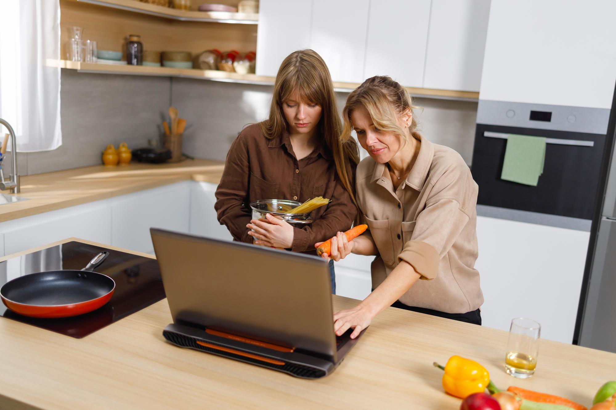 Student cooking at home with instructor on screen